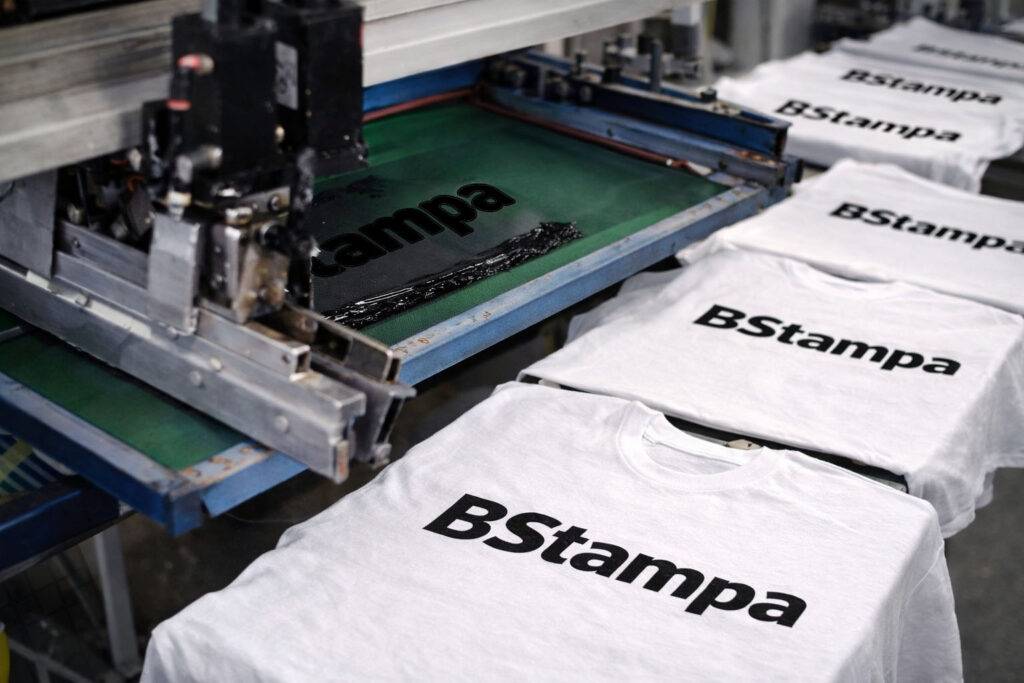 Telaio serigrafico durante la stampa su una t-shirt bianca